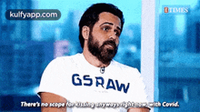 a man with a beard is wearing a gsraw t-shirt .