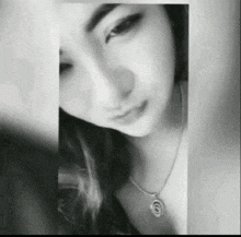 a black and white photo of a woman wearing a necklace with the letter s on it