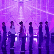 a group of people standing on a stage with purple lights
