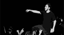 a man is singing into a microphone in front of a crowd of people .