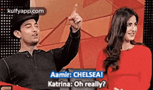 a man and a woman are standing next to each other and the man is pointing up while the woman is smiling .