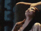 a woman sits in a chair with her head up and her eyes closed