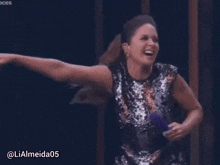 a woman in a sequined dress is holding a purple object and has the hashtag lialmeida05