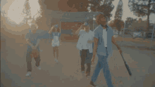 a group of people are walking on a baseball field one of them is holding a bat