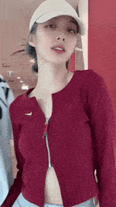 a woman wearing a nike hat and a burgundy sweater