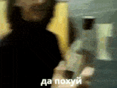 a blurry picture of a person holding a bottle with the words da poxyui written in white letters .