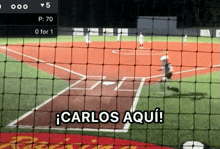 a baseball game is being played and carlos aqui is written on the fence