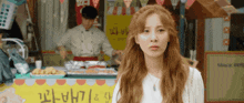 a woman standing in front of a food stand with a sign that says since 1980 on it