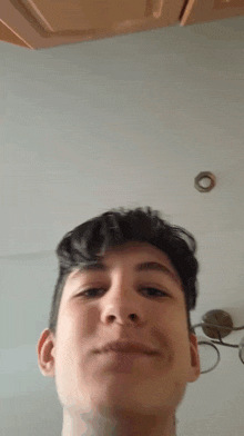 a young man is making a funny face in front of a wall .