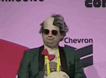 a man in a costume is standing in front of a sign that says chevron on it .