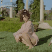 a blurry picture of a woman in a pink dress with her hair blowing in the wind