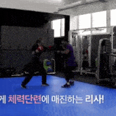 a man and a woman are boxing in a gym with korean writing on the floor .