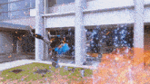 a person is doing a trick in front of a building with fire coming out of it