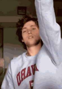 a young man wearing a sweatshirt that says drav