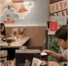 a group of people are sitting at a table in a restaurant .