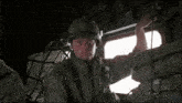 a man in a military uniform is looking out of a window .
