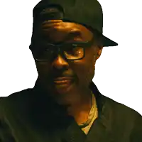 a man wearing a hat and glasses looks at the camera with a white background