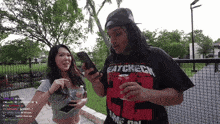 a man wearing a shirt that says catchech is holding a can of coke
