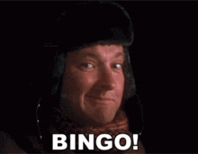 a man is wearing a hat and scarf and says bingo