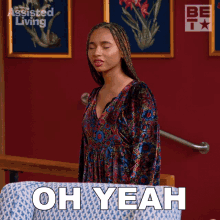 a woman in a dress says oh yeah in front of a red wall