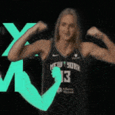 a woman in a new york jersey is flexing her arms .