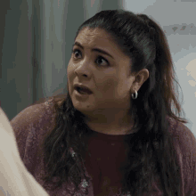 a woman with a surprised look on her face is wearing earrings
