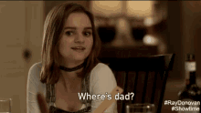 a woman is sitting at a table and asking where is dad