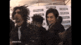 a group of people are standing in front of a wall that says kerrang