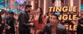 a group of people are dancing in front of a sign that says tingle