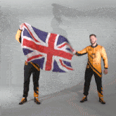 two men holding a british flag and one has the number 3 on his uniform