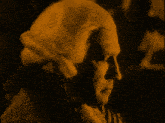 a man in a striped shirt is reading a piece of paper in a dark room