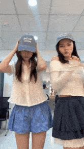 two girls wearing hats one of which says " i love you "