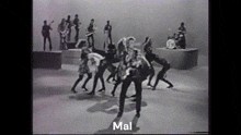 a black and white photo of a group of people dancing with the word mal in the lower right corner