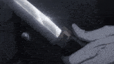 a close up of a person holding a sword with a button in the background