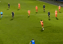 a group of soccer players are playing on a field and one of them is wearing a blue jersey