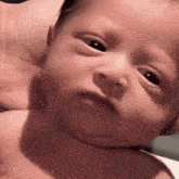 a close up of a baby 's face with a serious look on it 's face