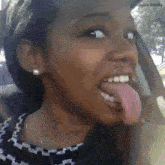a woman with a long tongue is sitting in a car with jukin media in the corner
