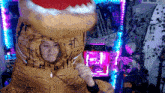 a woman is wearing a t-rex costume and dancing in front of a computer .