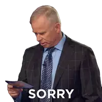 a man in a suit and tie is holding a piece of paper with the word sorry on it