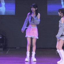 a girl in a pink skirt is holding a microphone