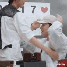 two men are hugging in front of a sign with the number 7 on it