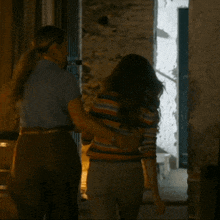 a man and a woman are walking down a hallway at night