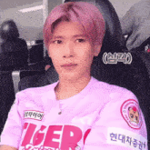 a man with pink hair is wearing a pink shirt that says tiger