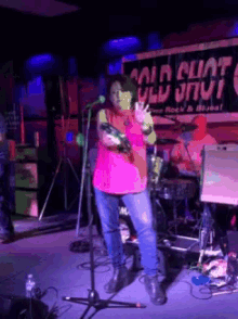 a woman singing into a microphone in front of a sign that says cold cunt on it