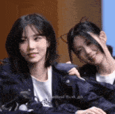a couple of girls are sitting next to each other .
