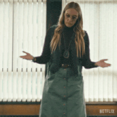 a woman standing in front of a window with netflix written on the bottom