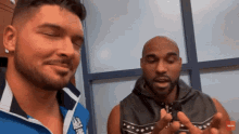 two men are standing next to each other and one of them is wearing a blue shirt that says adidas