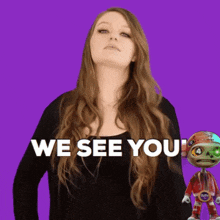 a woman is standing next to a robot that says " we see you "