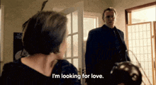 a woman says i 'm looking for love to a man in a suit
