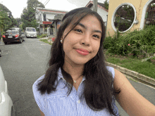 a woman taking a selfie with a car in the background and a yellow building